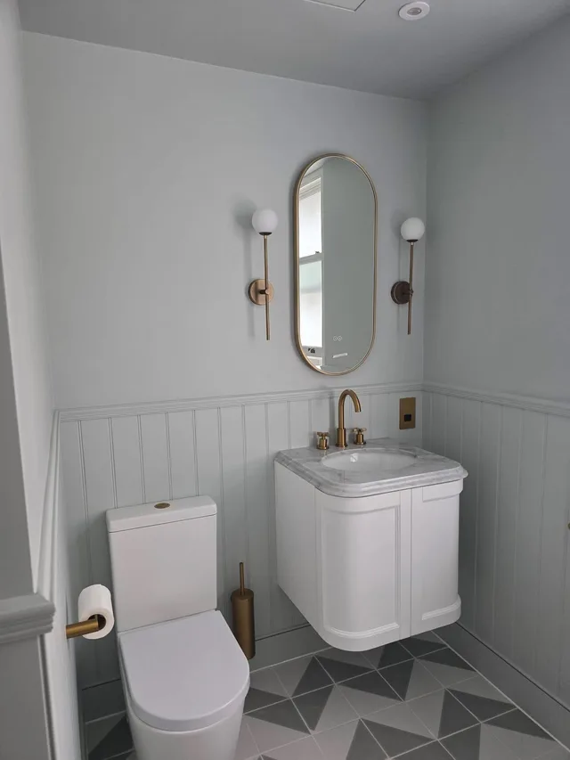 Completed bathroom with large-format stone tiling and fitted vanity